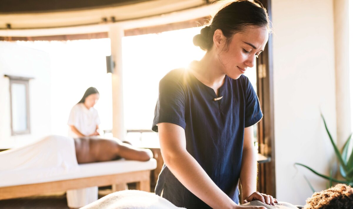 A licensed massage and bodywork therapist works with a client