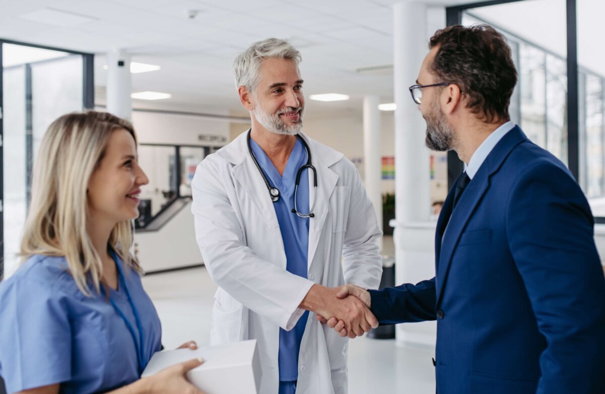 A doctor shakes the hand of a professional license defense attorney, preparing for a hearing before the NC Medical Board